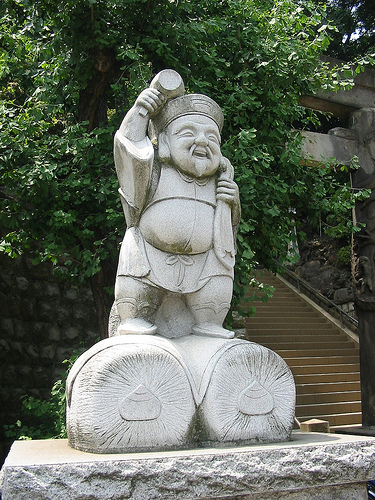 Creative Commons Photo by Stefan: Daikokuten is one of the Seven Gods of Fortune. He is the god of wealth, commerce and trade (hence the bales of rice under his feet).